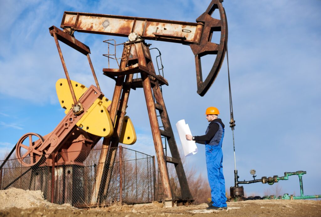 Petroleum engineer controlling work of oil well pump jack.