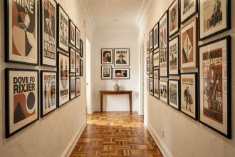 Couloir décoré d'une galerie d'affiches graphiques encadrées aux designs variés sur mur blanc